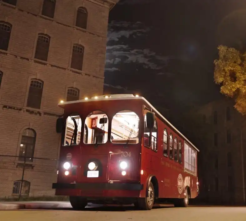 Red trolley parked at night in frpont of the Rockwood Insane Asylum in Kingston Ontario